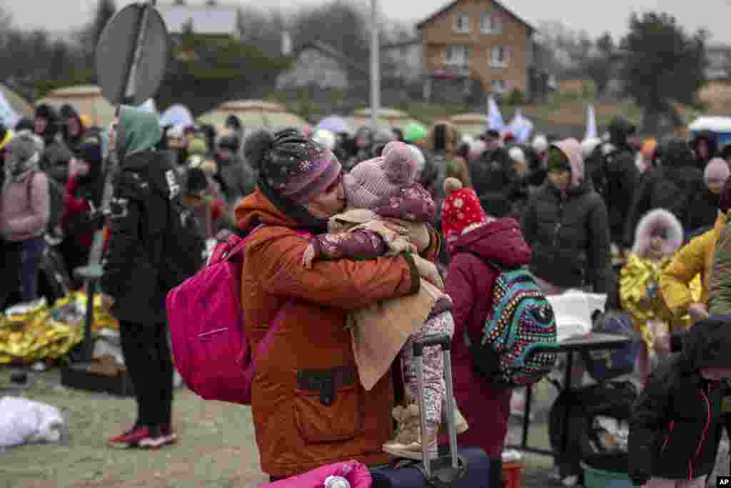 Una mujer besa a un niño después de huir de Ucrania y llegar al cruce fronterizo en Medyka, Polonia.
