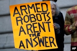 Diana Scott holds up a sign while taking part in a demonstration about the use of robots by the San Francisco Police Department outside of City Hall in San Francisco, Monday, Dec. 5, 2022. (AP Photo/Jeff Chiu, File)