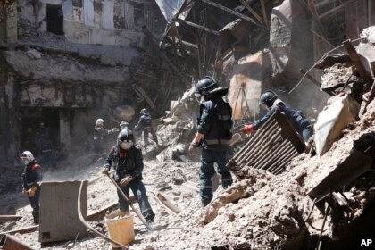Emergency Situations Ministry employees clear rubble at the side of the damaged Mariupol theater building during heavy fighting in territory under the government of the Donetsk People's Republic, May 12, 2022.  