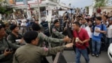 Riot police officers stop journalists from entering a blocked main street near the Cambodia National Rescue Party (CNRP) headquarters, on the outskirts of Phnom Penh, Cambodia, Monday, May 30, 2016. Police in Cambodia blocked an opposition protest march o