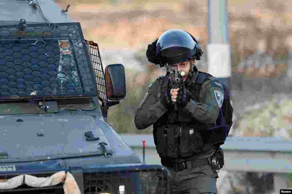 A member of the Israeli border police points his weapon during a clash with Palestinians at Beit El, near Ramallah, in the Israeli-occupied West Bank.