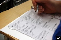 FILE - In this photo taken Jan. 17, 2016, a student looks at questions during a college test preparation class at Holton Arms School in Bethesda, Maryland. (AP Photo/Alex Brandon)