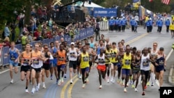 FILE - Elite runners make navigate the first mile of the 125th Boston Marathon, Oct. 11, 2021. 