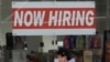 In this May 7, 2020, photo, a man wearing a mask walks under a Now Hiring sign at a CVS Pharmacy in San Francisco. California.