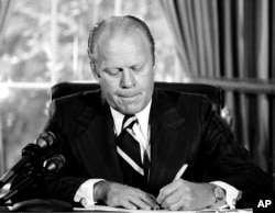 FILE - Ford signed a document granting Nixon "a full, free and absolute pardon" for all "offenses against the United States" during the period of his presidency.