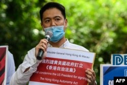 FILE - Holden Chow, member of the Democratic Alliance for the Betterment and Progress of Hong Kong (DAB), the largest Pro-Beijing party in the city, holds a placard outside the US Consulate in Hong Kong on July 16, 2020,