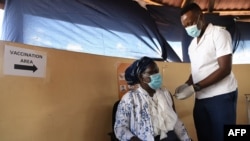 FILE - A health worker receives a dose of a COVID-19 vaccine, in Francistown, Botswana, March 26, 2021.