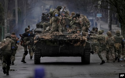 Ukrainian servicemen climb on a fighting vehicle outside Kyiv, Ukraine, April 2, 2022.  