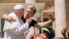 A man hugs Pope Francis to take a selfie after he had climbed on the popemobile at the end of the weekly general audience in St. Peter&#39;s Square at The Vatican.