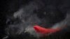 A plane dumps fire retardant chemicals onto a wildfire at the Sierra Bermeja mountain range, province of Malaga, Spain.&nbsp;(Photo by JORGE GUERRERO / AFP)