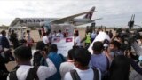 FILE - Journalists surround donated COVID-19 vaccines at the Phnom Penh International Airport in Phnom Penh, Cambodia, July 30, 2021. A report by a U.N. human rights agency finds increasing restrictions being placed on journalists, some related to COVID-19 measures.