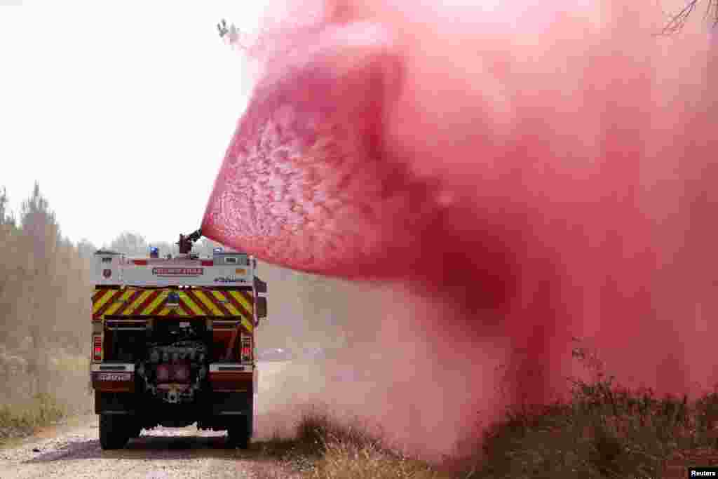 Firefighters use a chemical spray against a ground fire in the southwestern area of Gironde,&nbsp;France