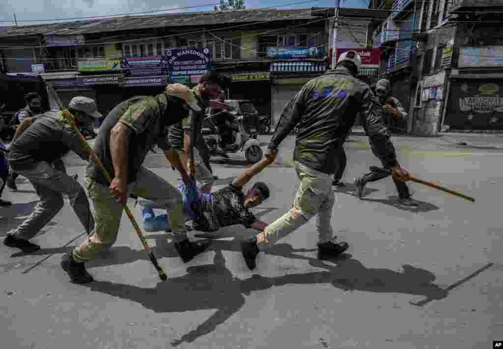 Indian policemen detain a Kashmiri Shi&#39;ite Muslim for participating in a religious procession during restrictions in Srinagar, Indian-controlled Kashmir, .