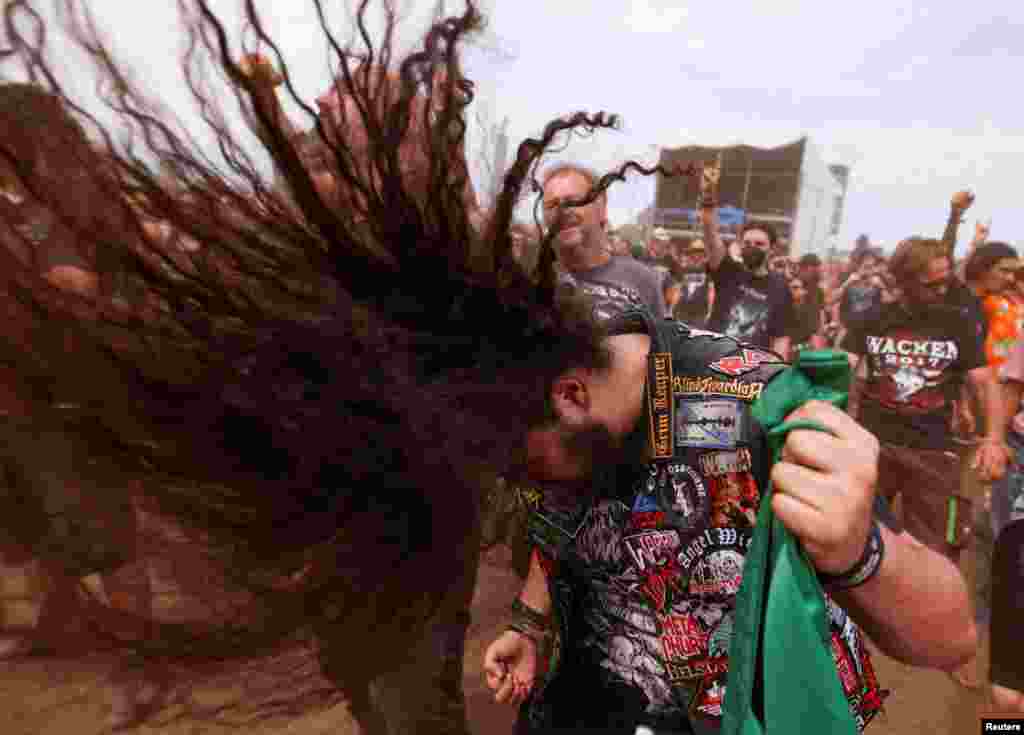 A person does a &quot;head bang&quot; during the Wacken Open Air 2022 heavy metal festival in Wacken, Germany.