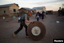 A young man rolls a tractor wheel in the Mennonite community of El Sabinal, Chihuahua, Mexico, April 22, 2021. (REUTERS/Jose Luis Gonzalez)