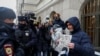 Полицейские разговаривают со сторонниками правозащитной группы «Мемориал», собравшихся у здания Верховного суда России в Москве, где было принято решение о закрытии организации 14 декабря 2021 года
