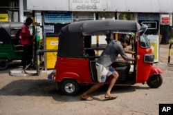 A man pushes his autorickshaw to a fuel station in Colombo, July 27, 2022. Sri Lanka's economic crisis has left the nation's 22 million people struggling with shortages of essentials, including medicine, fuel and food.