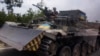 FILE - Ukrainian soldiers drive a tank on a road in Stupochky, Donetsk region, eastern Ukraine, July 10, 2022. 