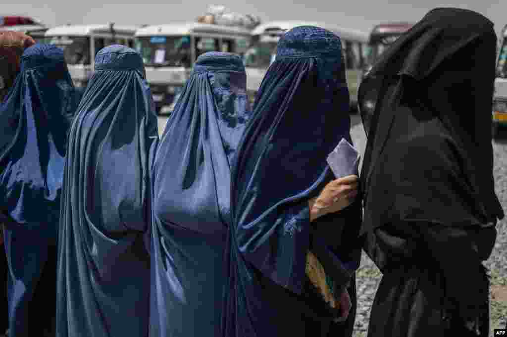 Afghan internally displaced refugee women stand in a queue to identify themselves and get cash as they return home to the east, at the United Nations High Commissioner for Refugees (UNHCR) camp in the outskirts of Kabul.
