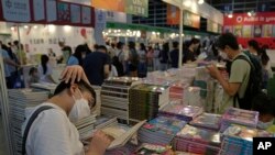 Visitors read at a booth during the annual book fair in Hong Kong, Wednesday, July 20, 2022. 