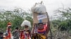 Місцеві жителі несуть коробки та мішки з їжею, яке розподілило Агентство США з міжнародного розвитку (USAID), у Качоді, район Туркана, на півночі Кенії, 23 липня 2022 року. (AP Photo/Desmond Tiro) 