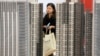 资料照：湖北武汉一名女子正在一个新楼盘售楼处观看。