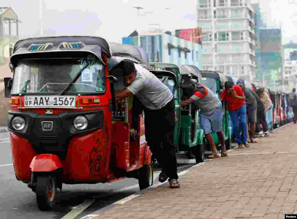 Drivers push auto rickshaws in a line to buy petrol from a fuel station, amid Sri Lanka's economic crisis, in Colombo, Sri Lanka.