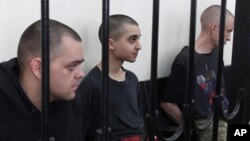 Ejden Aslin, Saudun Brahim i Šon Piner (s leva) iza rešetaka u sudnici u Donjecku (Foto: AP) 