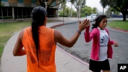 Native American students high fiving as they pass each other at the University of California, Riverside, June 26, 2014. 