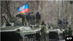 Люди в военной форме на фоне флага так называемой "ДНР". Архивное фото.