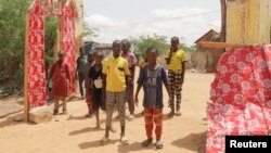 Bashir Nur Salat poses for a photograph with his classmates at the Kabasa Primary School in Dollow, Gedo Region, Somalia May 25, 2022. (REUTERS/Feisal Omar)