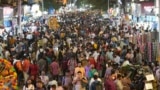 FILE - People crowd a market area outside a train station in Mumbai, India, Saturday, March 12, 2022. (AP Photo/Rajanish Kakade)