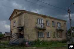 A man walks into his home damaged by Russian strikes, in Yahidne village, northern Chernihiv region, Ukraine, Wednesday, June 29, 2022. (AP Photo/Nariman El-Mofty)