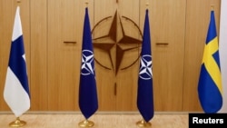 FILE - The flags of Finland, NATO and Sweden are seen during a ceremony to mark Sweden's and Finland's application for membership in Brussels, Belgium, May 18, 2022. 