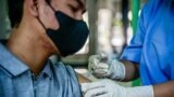 2023年12月19日，一名卫生工作者在雅加达省卫生办公室为一名男子接种 Covid-19 疫苗。（法新社照片）