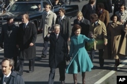FILE - This Jan. 20, 1977 file photo shows President Jimmy Carter and First Lady Rosalynn Carter waving as they walk down Pennsylvania Avenue in Washington after Carter was sworn in as the nation's 39th president. (AP Photo)