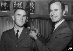George W. Bush, left, is shown with his father, George H.W. Bush, in this photo from 1968.