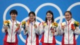 资料照片：中国女子4x200米自由泳接力队员在日本东京举行的2020年夏季奥运会上举着金牌合影。（2021年7月29日）