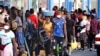 Haitianos, muchos de los cuales han estado esperando hasta un año en México para que se procesen sus solicitudes de asilo, hacen fila para recibir remesas de familiares frente a la tienda Salinas y Rocha, el 3 de septiembre de 2021, en Tapachula, México.