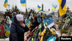 Украинцы приходят на могилы погибших родственников в Буче в годовщину войны