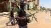 (FILE) A member of Sudanese armed forces looks on as he holds his weapon in the street in Omdurman, Sudan.