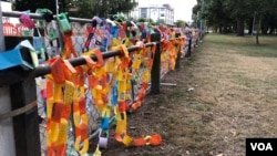 Paper links are draped over the fence at Hagley Park near one of the mosques were more than 40 people were killed in Christchurch March 15. (S. Miller/VOA)