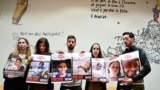 The photographs of missing persons or held hostages, From LtoR, Noam Avigdori, Tamar Gutman and Elia Toldano are held by relatives and acquintances including Adva Gutman (C), sister of Tamar Gutman, hostage of the rave party, during a meeting with a colle