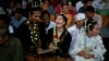 Sepasang pengantin tertawa gembira membaca surat nikah mereka saat pernikahan massal yang digelar di Jakarta (foto: ilustrasi). 