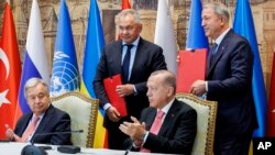 资料照片：俄罗斯国防部新闻局公布的照片显示土耳其总统埃尔多安、联合国秘书长古特雷斯与俄罗斯国防部长绍伊古和土耳其国防部长阿卡尔在伊斯坦布尔举行的《黑海谷物倡议》签署仪式上交换文件。(2022年7月22日)