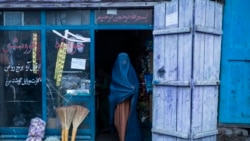 Una mujer afgana vestida con un burka sale de una pequeña tienda en Kabul, Afganistán, el domingo 5 de diciembre de 2021. [Foto AP/Petros] Giannakouris]