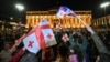 Georgian pro-democracy groups activists wave flags of Georgia as they protest against a repressive "foreign influence" bill outside the parliament in Tbilisi on April 15, 2024.