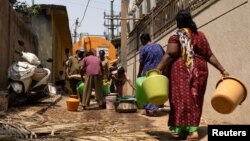 Residents arrive to fill their containers with drinking water from a tanker in a neighborhood that is facing severe water scarcity in Bengaluru, India, March 11, 2024. The U.N. marks World Water Day on March 22 and warns of the growing risk of conflict over scarce water.