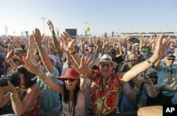 Festival-goers cheer at the New Orleans Jazz and Heritage Festival in New Orleans, Sunday, May 3, 2015.