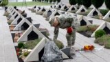 Тбилиси. Грузинская военнослужащая навещает могилу однополчанина, погибшего в августе 2008 г. (архивное фото) 